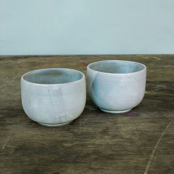 Zwei Keramikbecher auf Holztisch