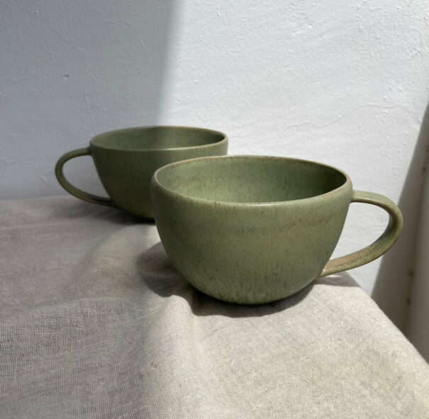 Two green ceramic cups on tabl