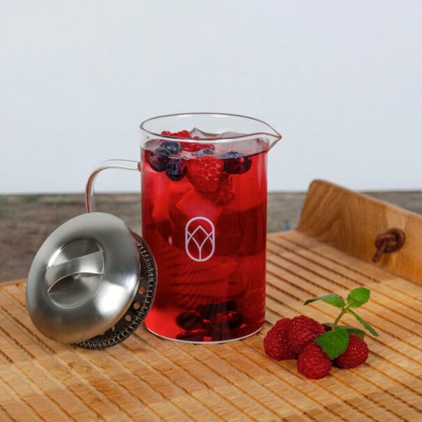 Teekanne Glas Iced Tee und Beeren auf Holztisch